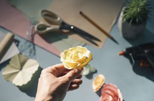 Female hand holding a paper rose