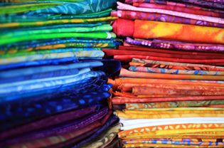成堆的折叠蜡染布在众多的颜色。