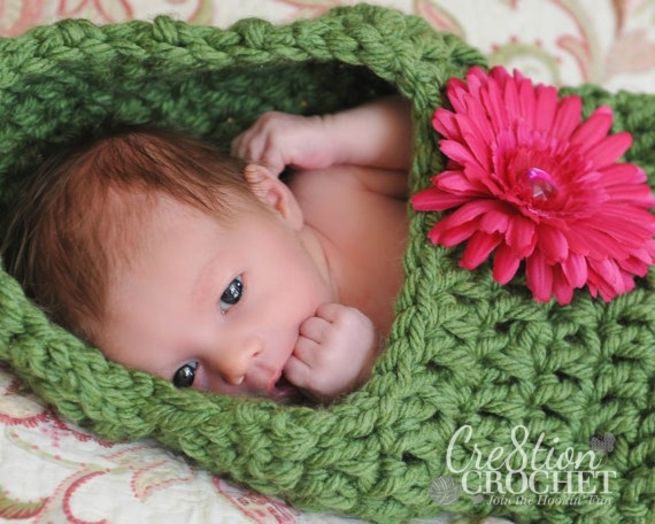 婴儿在豆荚花茧钩针图案躺在毯子上