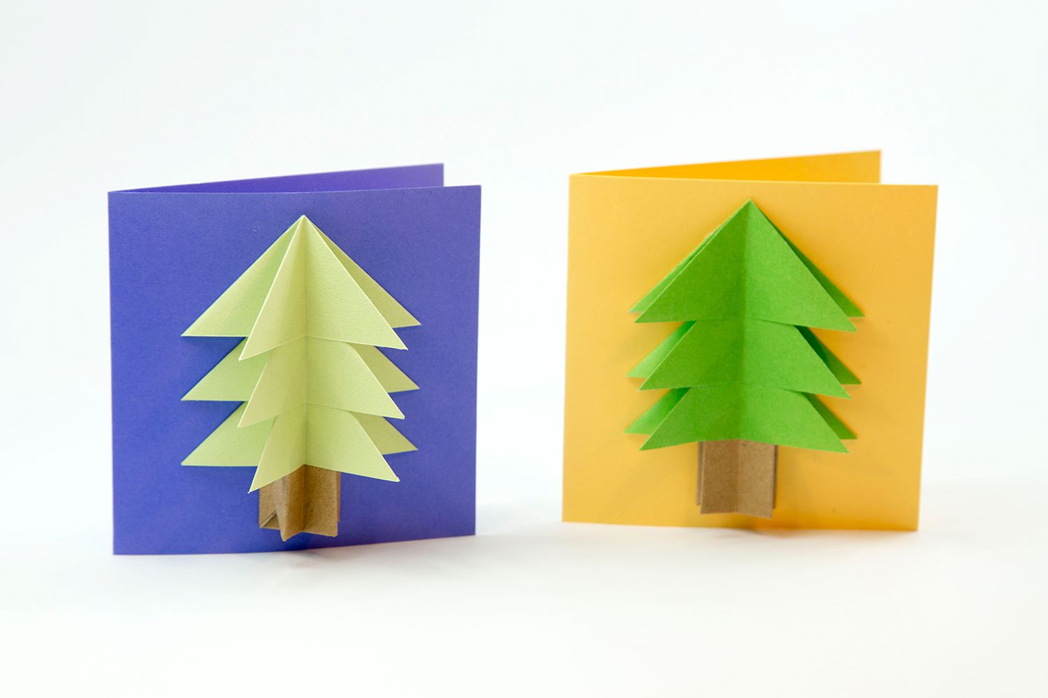 Two origami Christmas tree cards, one with a blue and other orange background.