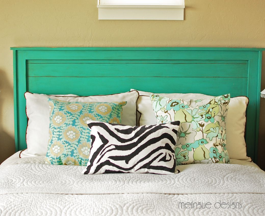 一张床和一个DIY木制床头板漆成绿色