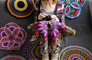 woman crocheting on the floor