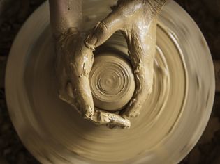 一个女人使用陶器的陶工旋盘