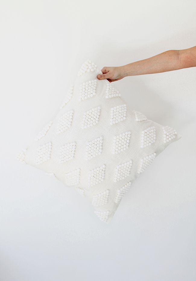 一个DIY现代几何枕头用白色的绒球