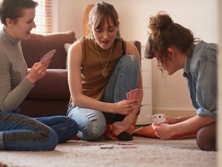 3个女孩在客厅里玩纸牌游戏