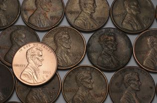 三排旧硬币和一排闪亮的新硬币