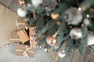 特写镜头下的圣诞礼物雪用淡棕色饰品装饰冷杉树。