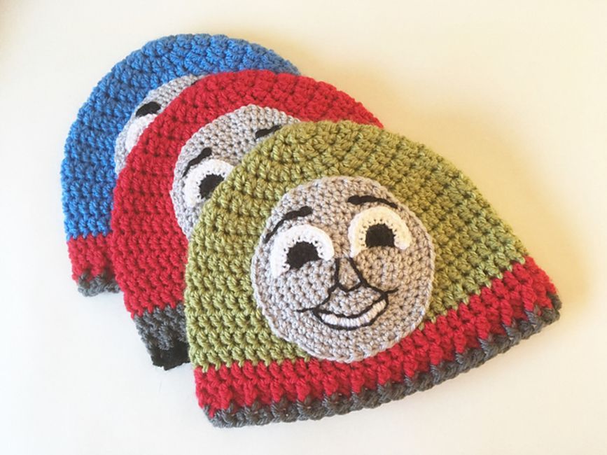 三个小孩帽子绿、红、蓝和火车的脸在前面. .