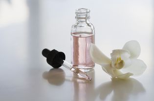 flower and bottle of essential oil perfume