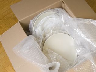 白色陶瓷板包裹在气泡膜堆在一个移动的盒子里
