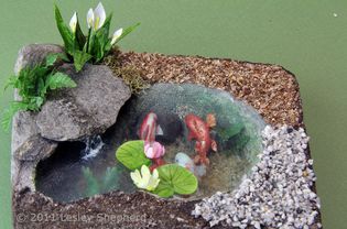 Range of materials used to landscape a dolls house scale fish pond