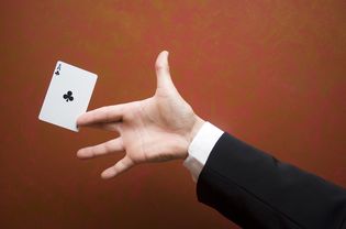 Close-up of magician performing trick with ace card