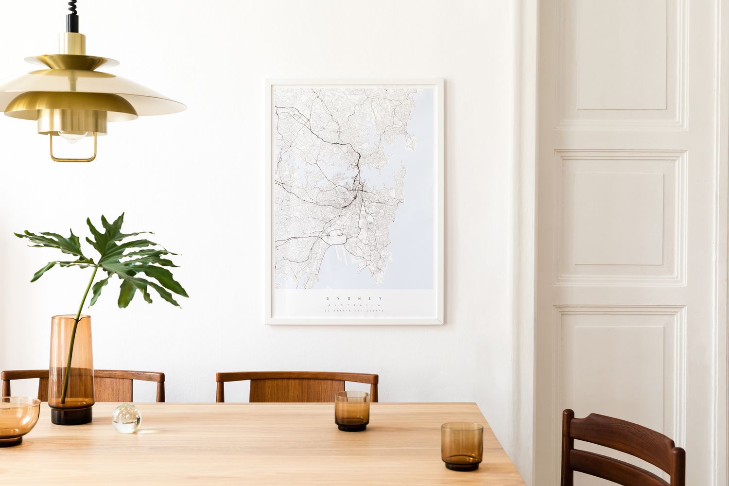时尚和现代的餐厅内部与模拟海报地图，共享桌子设计椅子，金色吊灯和咖啡杯。白墙，镶木地板。花瓶里的热带叶子。折衷的装饰。