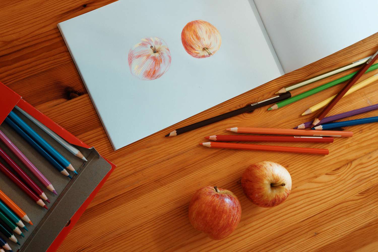 使用彩色铅笔在桌子上画出两个苹果