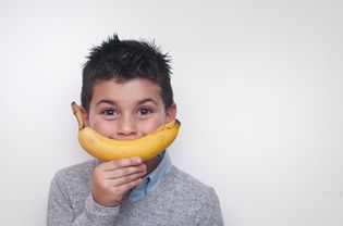 快乐的男孩拿着一根香蕉