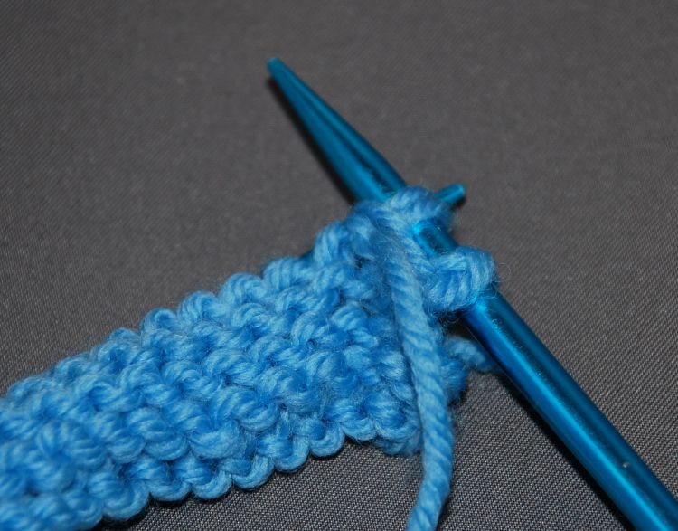 Purl in the front and back of a stitch while knitting
