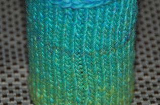 Knit cozy for a bottle or can.