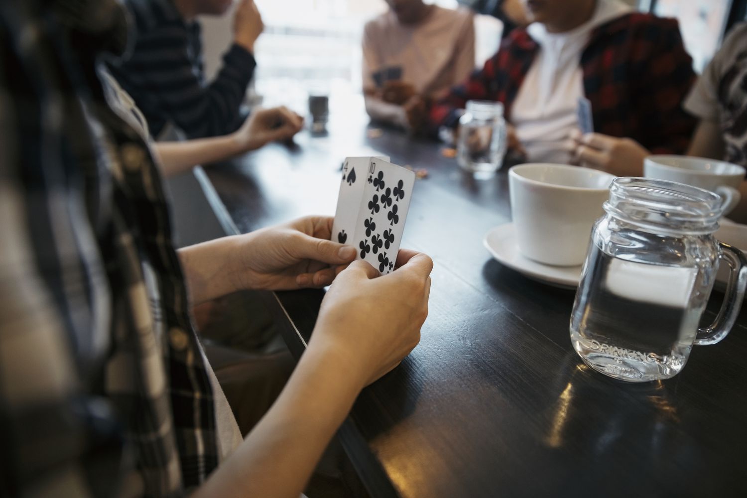 小男孩和朋友在咖啡桌上打牌