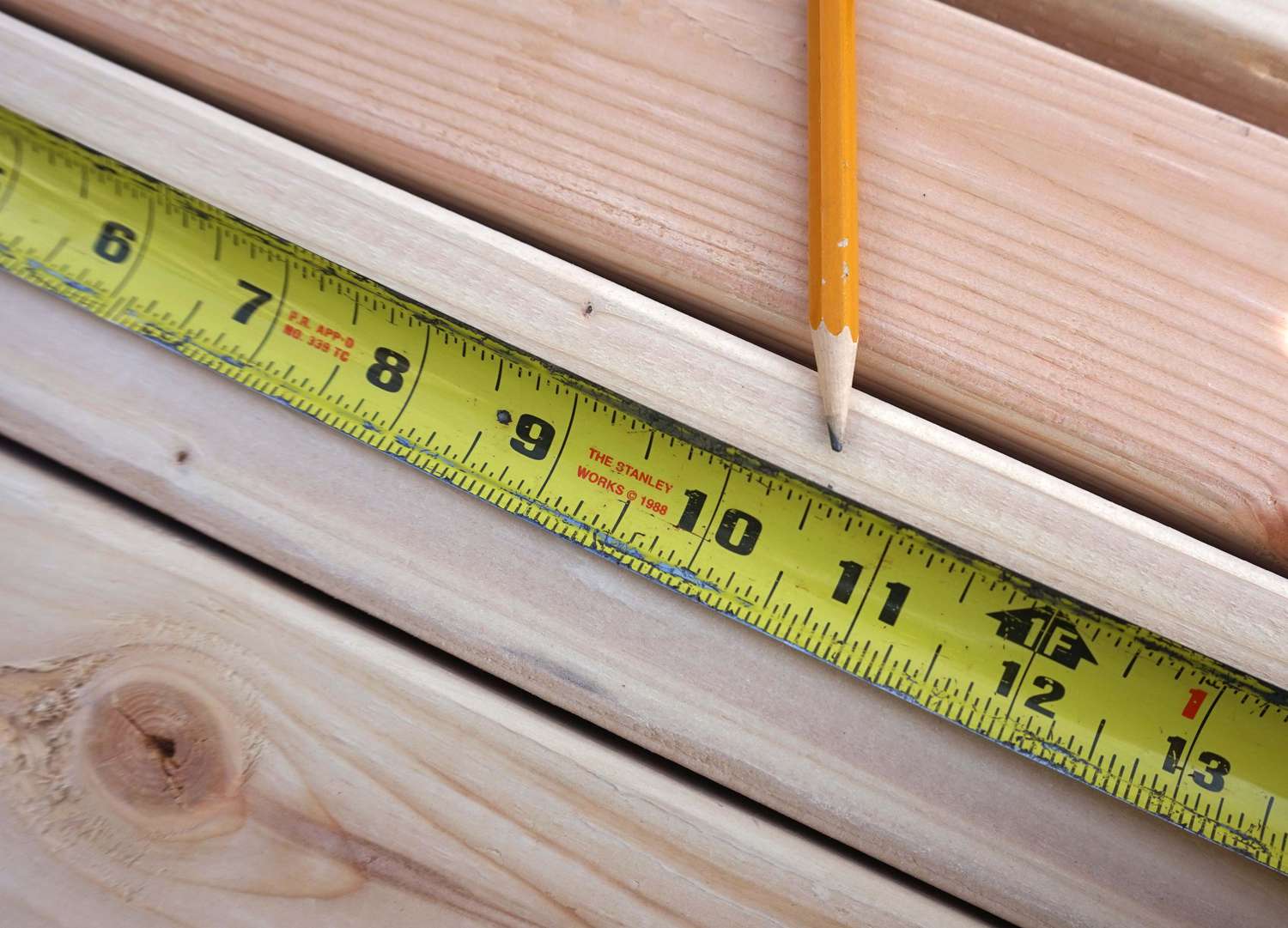 一支铅笔和卷尺标志着木板