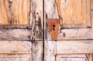 圣达菲风格:豆科灌木木门与生锈的锁孔(细节)