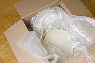 白色陶瓷板包裹在气泡膜堆在一个移动的盒子里