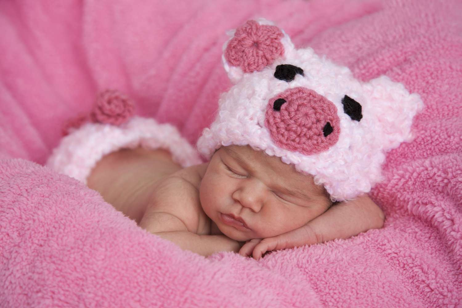 Newborn baby girl dressed in pink piggy outfit