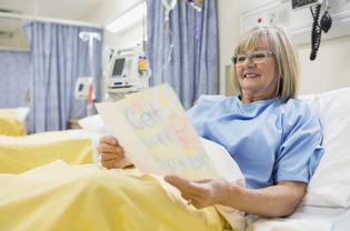 Senior woman reading a get well card in the hospital