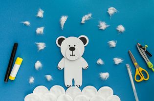 简单的工艺,孩子。冬天贺卡极地白熊从纸和棉盘。孩子们的艺术项目。DIY的概念。
