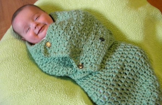 婴儿在襁褓中编织图案躺在毯子上