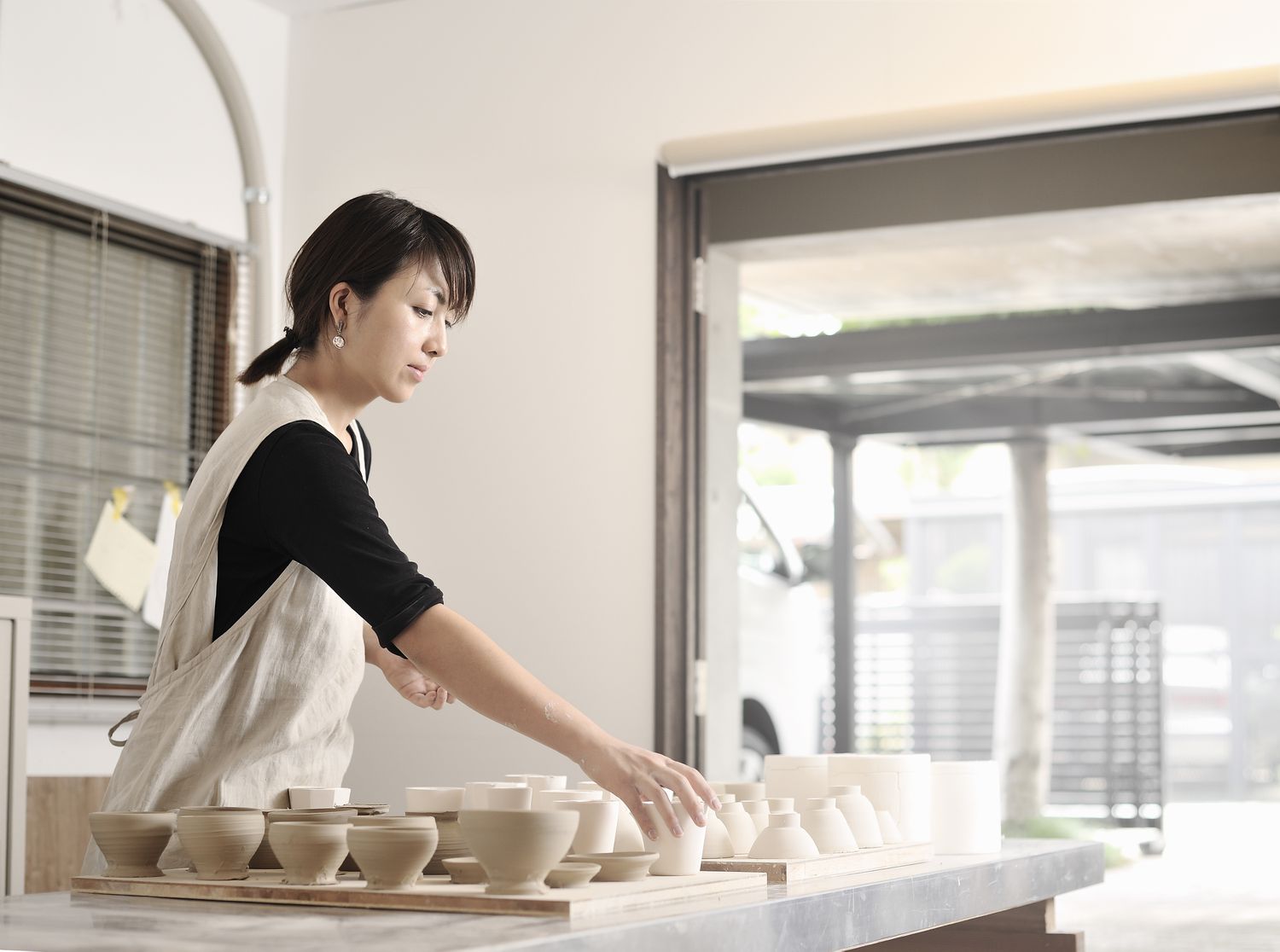 一个女人波特在她的陶艺工作室在日本工作
