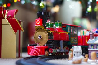 Christmas train under tree with wrapped gifts