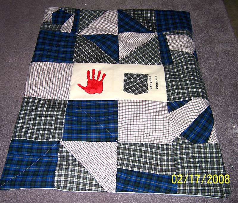蓝色、灰色、和白色法兰绒红手印的被子缝在中间。