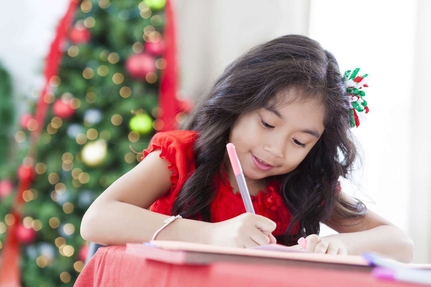 一个小女孩写前面的一棵圣诞树