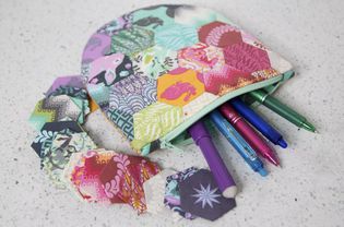 A hexagon zipper pouch filled with pens and pencils