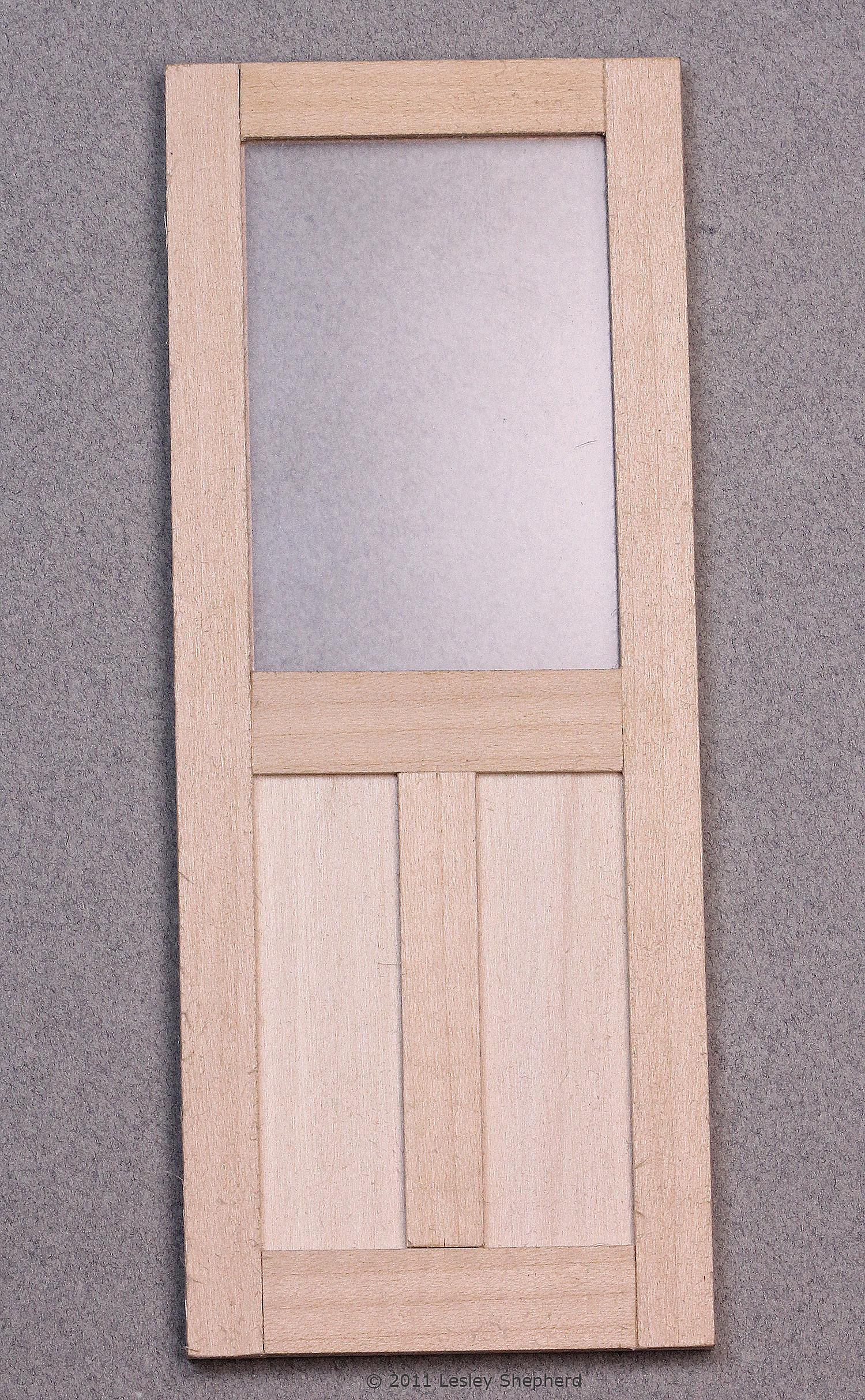 Simple dolls house door with window and panel trim.