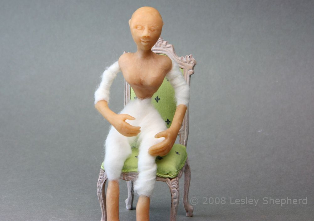 A doll house doll showing the wire armature wrapped with batting.