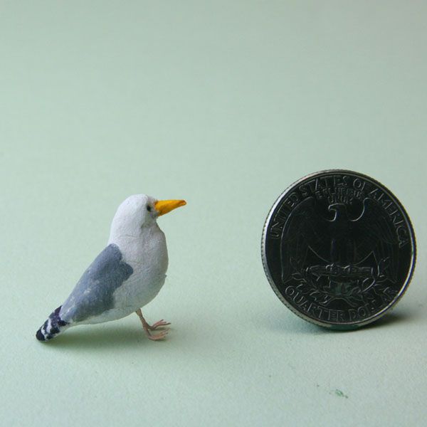 The wire legs and feet of a miniature seagull are set in place under its body.