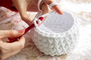 Young Woman While Crocheting Close Up. Stay At Home Leisure Activity Idea. Basket Made Of White Yarn