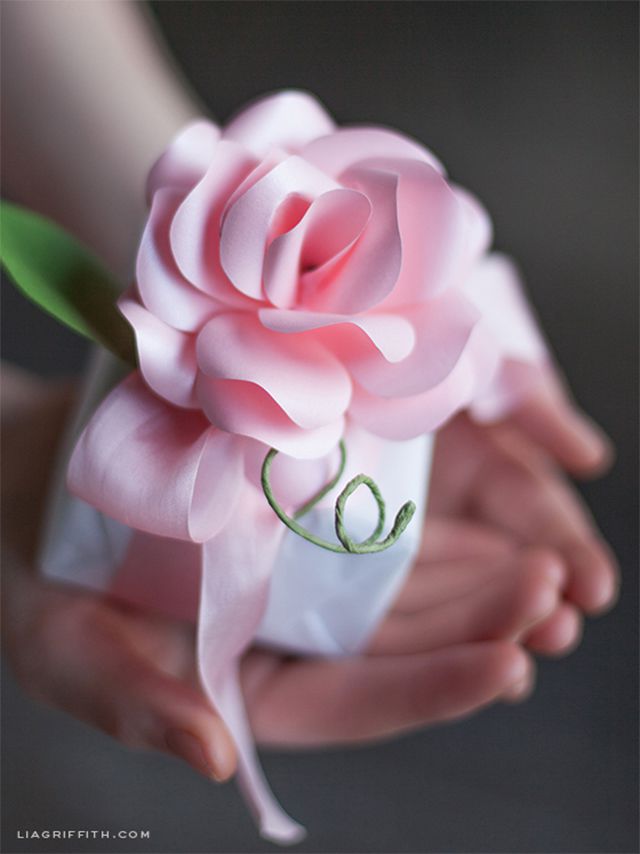 一个女人拿着礼物顶部设有一个粉红色的纸玫瑰