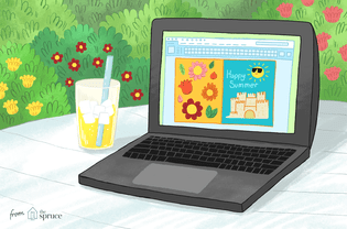 一台笔记本电脑坐在外面，旁边是一杯柠檬水，屏幕上有夏天的剪贴画。