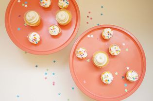 Pink cupcake trays with vanilla cupcakes and confetti.