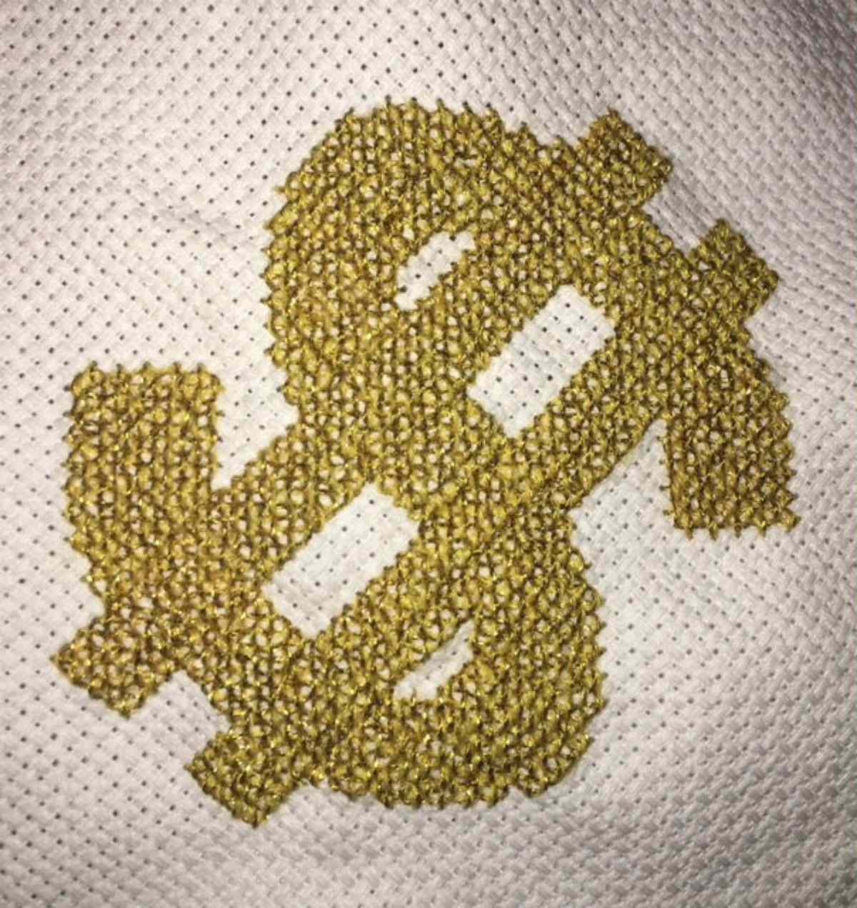 完成一美元符号在黄金十字绣计数。