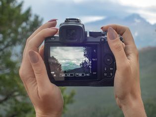拍照的的黑色相机举起和mountainscape特写镜头