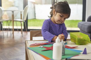Girl crafting animals on children's table