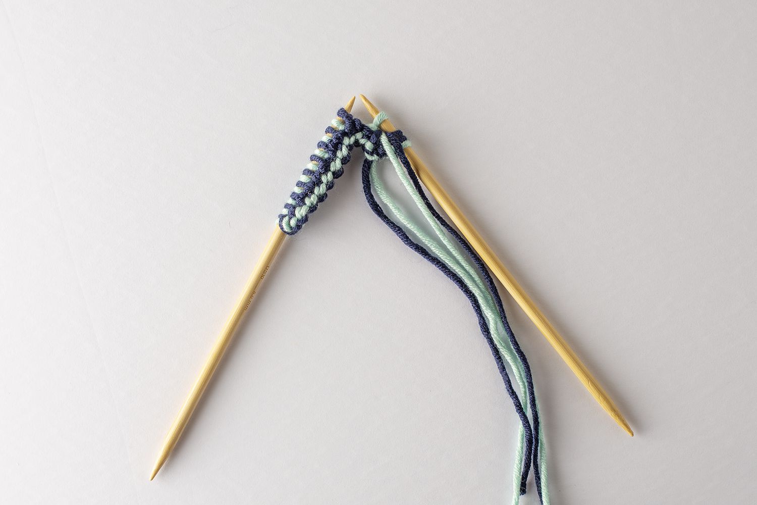 两根木制针织针编织纱线。