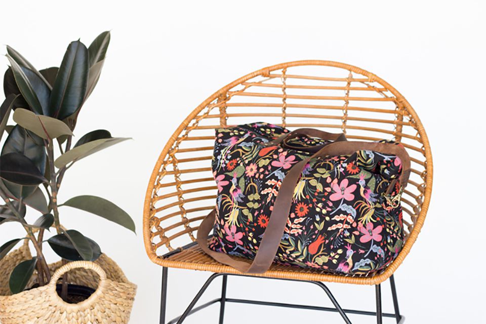 一个带花的行李袋放在藤椅上
