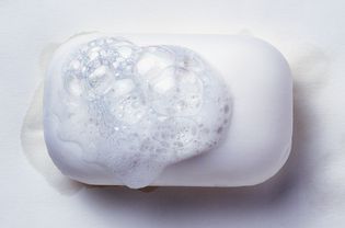 A bar of white soap with soap suds on it