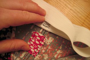 Preparing to attach waistband, anchoring the tag with fusible web