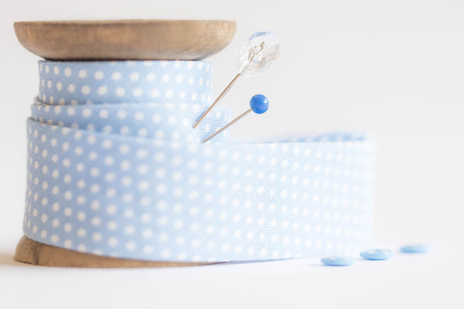 Blue and white spotted bias binding on spool with pins