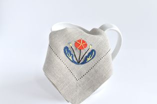 折叠在水罐上的斯堪的纳维亚绣花花餐巾